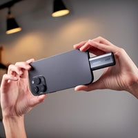 Black ADATA SC750 1TB USB-C portable SSD connected to a smartphone, showcasing its compact design and versatility.